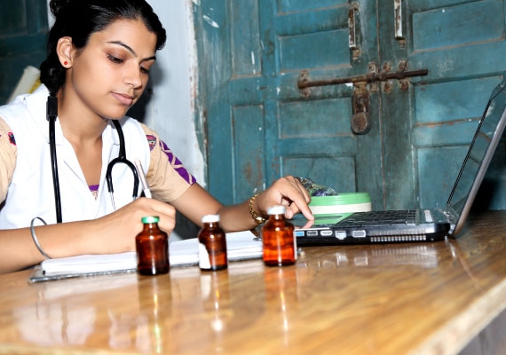 young Indian doctor working on laptop and prescribing abortion pills